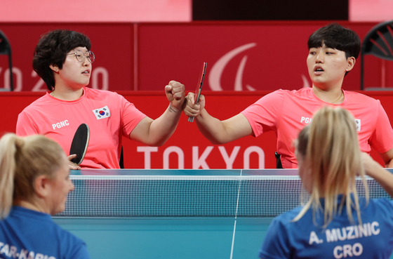 Lee Mi-gyu, left and Yoon Ji-yu celebrate defeating Croatia in the women’s team class one to three semifinals in two straight matches at the Tokyo Metropolitan Gymnasium in Tokyo on Wednesday. [YONHAP]