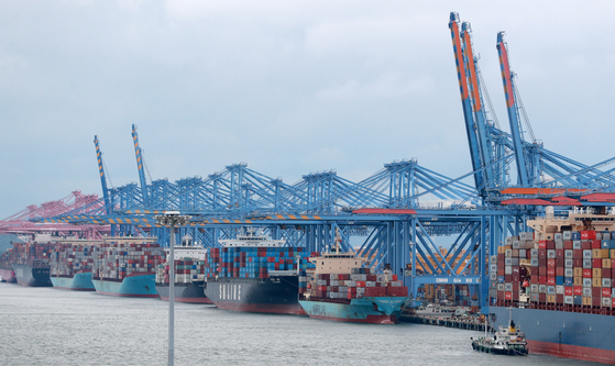 Export goods in cargo containers being loaded onto ships scheduled to travel aboard at the port in Busan on Wednesday. Exports in August grew 34.9 percent. Exports have been growing for 10 consecutive months. [YONHAP]