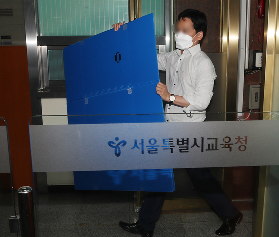 An official of the Corruption Investigation Office for High-ranking Officials enters the Seoul Metropolitan Office of Education on Tuesday to raid the office of Seoul's superintendent for education, Cho Hee-yeon, who has been accused of allegedly abusing his power to hire back sacked teachers. [YONHAP]