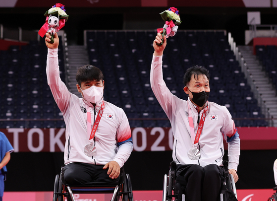 Kim Jung-jun and Lee Dong-seop pose after winning silver in the men's doubles WH badminton tournament at the 2020 Paralympics in Tokyo on Sunday. [YONHAP]