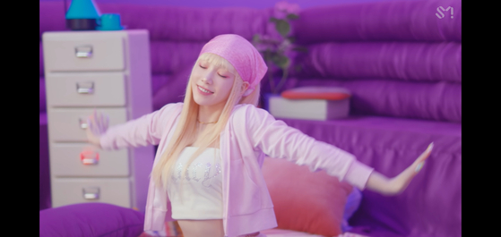 Taeyeon of Girls' Generation wears a bright pastel-colored bandana and crop top in her music video for "Weekend" (2021). [SCREEN CAPTURE]