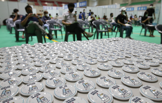 Covid-19 vaccination badges, made to encourage inoculations, are displayed at a vaccination center in Daejeon on Tuesday. More than 60 percent of the country's 52-million population had received one dose of a Covid-19 vaccine as of 10:30 a.m. Tuesday. [NEWS1]