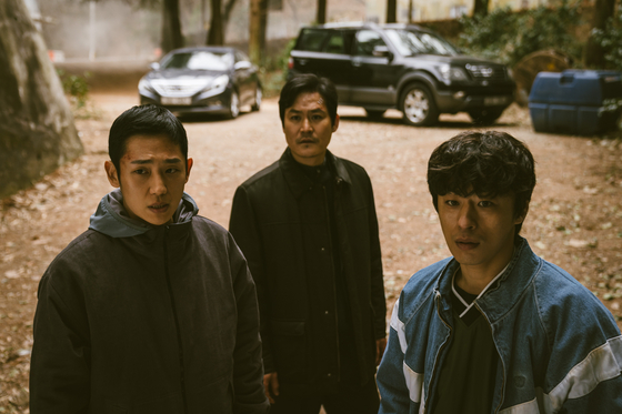 Private An Jun-ho (played by Jung Hae-in), left, and Corporal Han Ho-yeol (played by Koo Kyo-hwan) in front, and their superior Park Bum-gu (played by actor Kim Sung-kyun) attempt to locate an escapee, a Private First Class named Cho Suk-bong. [NETFLIX] 