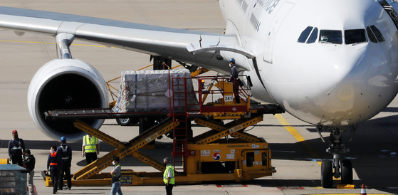 Workers move boxes carrying some 976,500 doses of Pfizer and Moderna vaccines from a chartered plane at Incheon International Airport on Wednesday. This is the second batch of some 1.5 million doses Romania has agreed to provide Korea in exchange for vaccines and other medical supplies. [YONHAP]