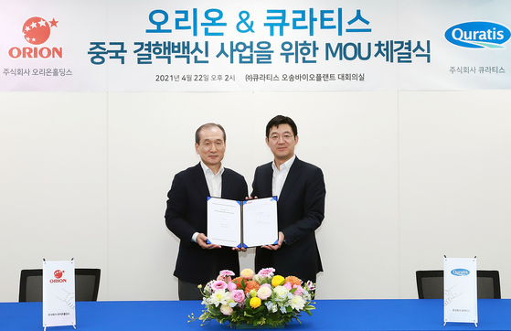 Heo In-cheol, left, vice chairman of Orion Holdings, and Quratis CEO Cho Kwan-gu take a photo after signing a memorandum of understanding for the technology transfer of a tuberculosis vaccine, on April 22 in Quratis’ plant in Cheongju, North Chungcheong. [ORION HOLDINGS]