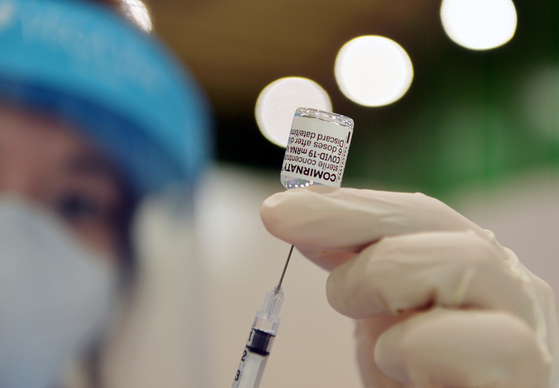 A nurse loads a syringe with the Pfizer Covid-19 vaccine. [KIM SEONG-TAE]