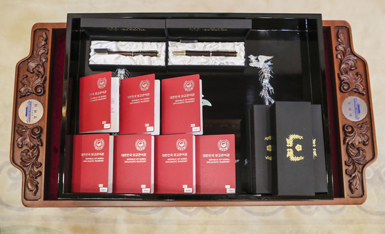 Korean diplomatic passports and fountain pens presented to BTS at a ceremony appointing the seven boy band members as special presidential envoys at the Blue House Tuesday. [JOINT PRESS CORPS]