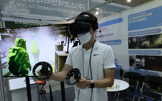 An employee of a company that develops virtual reality training programs demonstrates the handling of an industrial accidents involving dangerous chemicals at the Korea International Construction & Industrial Safety Expo held at Kintex in Goyang, Gyeonggi, on Tuesday. [YONHAP]