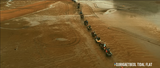 The Korea Tourism Organization unveiled a series of promotional videos earlier this month, and one on Seosan features locals riding tractors on a tidal flat. The scene is a parody of 2015 film ″Mad Max: Fury Road,″ and the video is titled Mudmax. [SCREEN CAPTURE]