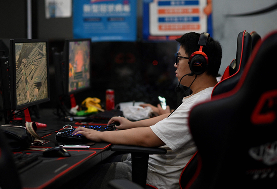 A man plays an online game at a computer shop in Beijing on August 31, 2021, a day after China announced a drastic cut to children's online gaming time to just three hours a week in the latest move in a broad crackdown on tech giants. [AFP/YONHAP]
