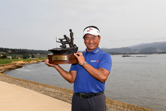 K.J. Choi holds the trophy on the 18th green at Pebble Beach Golf Links after winning the PURE Insurance Championship on Sunday in Pebble Beach, California.  [AFP/YONHAP]