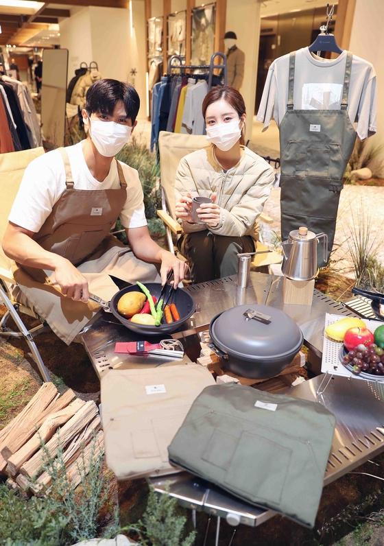 Models try Snow Peak camping equipment at Shinsegae Department Store in Gangnam District, southern Seoul. Aprons and lightweight padded jackets exclusive to Shinsegae Department Store's Snow Peak stores will be available starting Monday. [SHINSEGAE DEPARTMENT STORE] 