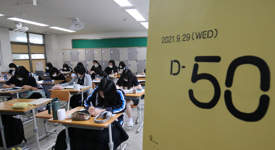 High school seniors in Goejeong High School in Daejeon study in a classroom on Wednesday next to a sign saying there are 50 days left until the College Scholastic Ability Test (CSAT). [NEWS1]