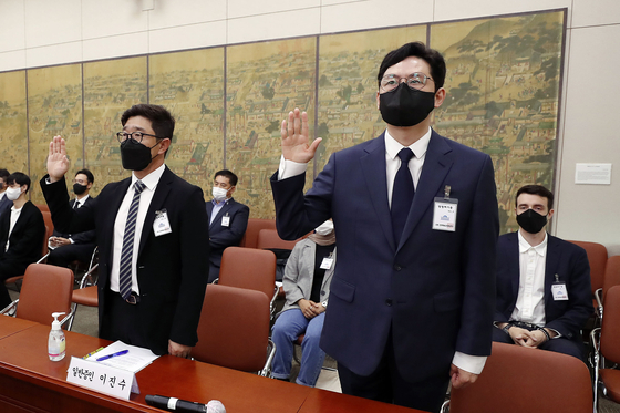 Kim Jun-koo, CEO of Naver Webtoon, right, and Lee Jin-soo, CEO of Kakao Webtoon, takes a vow before testifying at the National Assembly audit on Oct. 1. [YONHAP]
