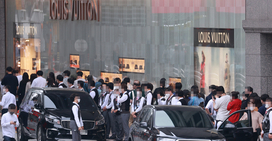Customers line up outside a Louis Vitton store at a department store in Seoul on Monday. Sales of luxury goods, from bags to watches and jewelry, have surged in the last year. Based on data provided by the National Tax Service and the Korea Custom Service, the individual consumption tax imposed on high-end imported bags alone amounted to 25.6 billion won ($22 million) in 2020, which is a 38.1 percent increase year-on-year. Based on estimates of the individual consumption tax on bags, sales of such luxury bags are believed to have amounted to roughly 174.1 billion won. [YONHAP]