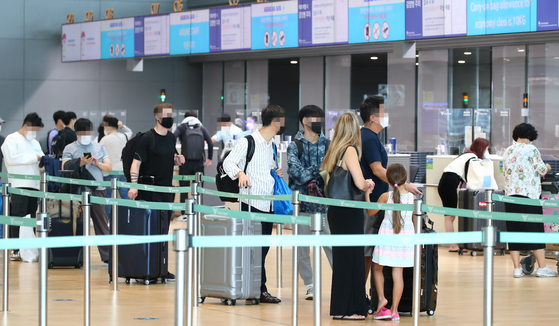 Passengers wait to check in at Terminal 2 of Incheon International Airport on Monday. As some European countries are exempting fully-vaccinated people from quarantines, an increasing number of tourists are taking Europe tour packages. Recently Lotte Tour and Hanjin Tour offered tours to France and Switzerland.  [YONHAP]