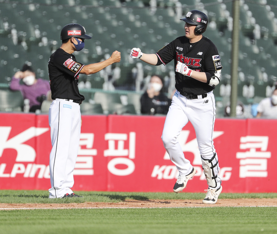 Yoo Han-joon, right, rounds the bases after hitting a three-run home run at the top of the third inning in a game against the Lotte Giants in Busan on Friday. [YONHAP]