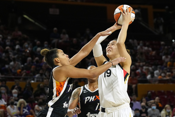 Las Vegas Aces center Park Ji-su, right, shoots over Phoenix Mercury guard Bria Hartley during the second half of a WNBA basketball game on Sunday in Phoenix. [AP/YONHAP]