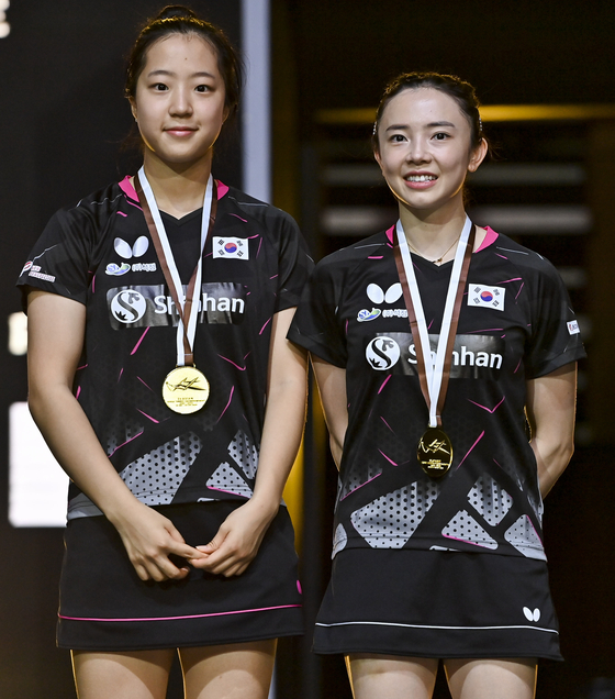 Shin Yu-bin, left, and Jeon Ji-hee pose on the podium during the award ceremony of the women's doubles final against Doo Hoi Kem and Lee Ho Ching of China's Hong Kong at the 2021 ITTF-ATTU Asian Championships Doha in Doha, Qatar on Tuesday. [XINHUA/YONHAP]