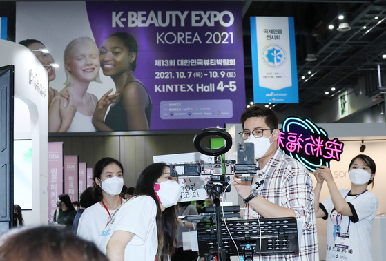 An influencer broadcasts live from K-Beauty Expo at Kintex in Goyang, Gyeonggi on Thursday. The expo, which is celebrating its 13th anniversary this year, is being held for three days. Before the pandemic, the K-Beauty Expo was a major beauty convention, attracting more than 2,000 overseas buyers from 37 countries and 50,000 visitors every year. [YONHAP]