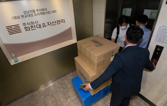 Investigators from the state prosecution service move materials collected in a raid on Hwacheon Daeyu's office in Seongnam, Gyeonggi on Wednesday. [YONHAP]