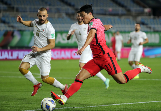  Hwang Hee-chan, right, plays the ball in the third round of qualifiers for the 2022 Qatar World Cup at Ansan Wa Stadium in Ansan, Gyeonggi on Thursday. [NEWS1]