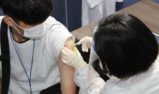  A 12th grad student gets a Covid-19 vaccine at an inoculation center in Busan, July 19. [SONG BONG-GEUN]