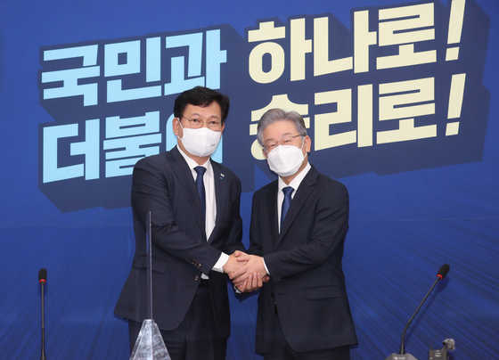 Song Young-gil, chairman of the ruling Democratic Party (DP), left, and Gyeonggi Gov. Lee Jae-myung, the DP’s presidential candidate, shake hands at the National Assembly in western Seoul Monday. [YONHAP]