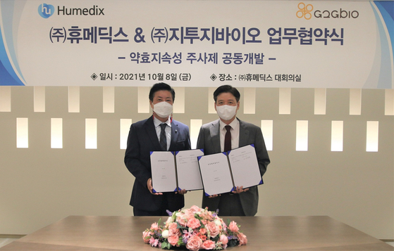 Humedix CEO Kim Jin-hwan, left, and G2GBIO CEO Lee Hee-yong, pose for a photo after signing an agreement to cooperate in developing long-acting injectable drugs. [HUMEDIX]