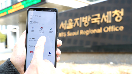 Tax paid via mobile in front of the National Tax Service's Seoul office. The government continues to see increase in taxes this year thanks to economic recovery and rising asset value including real estate. [YONHAP]
