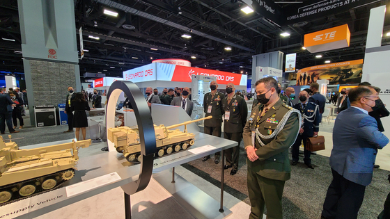 A military officer watches a miniature model of a Korean self-propelled howitzer exhibited at the Hanwha Defense booth during the Association of the United States Army (AUSA) 2021 expo held in Washington, D.C. on Tuesday. Every year some 800 major defense contractors, including Hanwha Defense, from various countries attended the annual event. This year the Korean defense developer exhibited its K-9 self-propelled howitzer and its infantry fighting vehicle Redback. Earlier in May, Hanwha Defense established Hanwha Defense USA. [HANWHA DEFENSE]