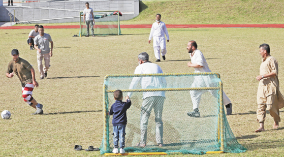 Afghans evacuated from Kabul to Seoul in late August play football together in field at a government facility in Jincheon County, North Chungcheong, on Wednesday. They will be staying at the facility through next February to participate in programs such as language classes and job search mentoring to help them adjust to life in Korea. [PARK SANG-MOON]