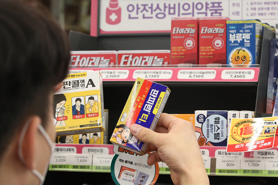 A customer picks up cold medicine at a CU convenience store on Monday. More people bought medicine at CU stores due to the sudden chilly weather, and the company announced that cold medicine sales between Oct. 11 and 17 rose 40.9 percent from the previous week. [YONHAP]
