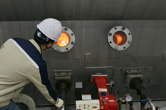 An Eco Creation employee operates a machine to extract pyrolysis oil from plastic waste Monday afternoon in its plant in Incheon. [SK GEO CENTRIC] 