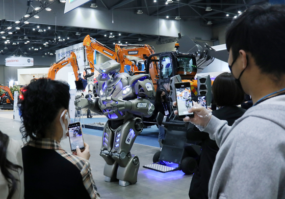 Titan the Robot, a 2.4-meter tall entertainment robot developed by Britain’s Cyberstein Robots, greets customers visiting the Digital Transformation Fair 2021 held at Kintex, Gyeonggi on Tuesday. This year, 400-plus companies specializing in artificial intelligence, automation and robotics, including Hyundai Doosan Infracore, are participating in the exhibition, which runs through Friday. A key issue being discussed in one of the sessions is digital innovation, including smart industrialization as well as the metaverse, in a time when humanity has to live with the coronavirus. [YONHAP]