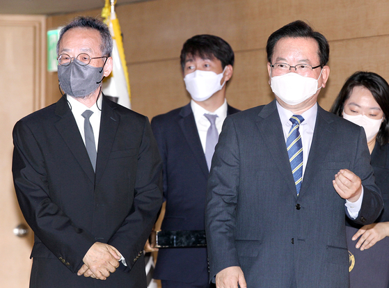 Prime Minister Kim Boo-kyum, right, and Choe Jae-chun, distinguished professor of EcoScience at Ewha Womans University, left, enter the inaugural meeting of a government-private sector committee at the government complex in Seoul on Wednesday. [NEWS1]