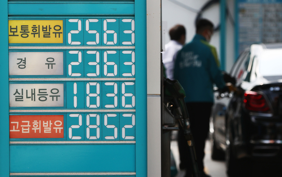 A customer pumping fuel into a car at a gas station in Seoul on Tuesday that is selling gasoline at 2,563 won per liter. The government is considering of cutting fuel taxes to ease burden amid fear of inflation. [YONHAP]