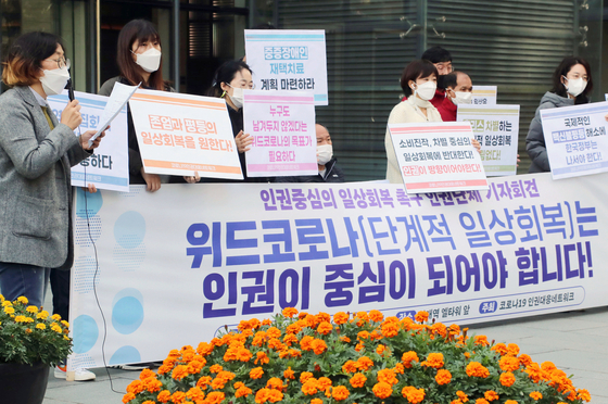 Activists call on the government to consider human rights when planning the so-called "With Corona" scheme, a set of new and relaxed rules on social distancing expected to be implemented next month, in Seocho District, southern Seoul, on Friday. [YONHAP] 