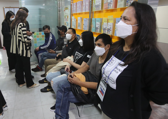 Foreigners wait to receive a vaccine at a visiting vaccination center in the Busan Foreign Residents Center in Sasang District, Busan, on Sunday. [SONG BONG-GEUN]