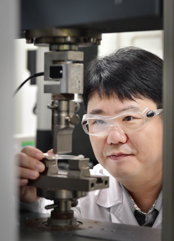 A researcher from LG Chem inspects the first eco-friendly recycled acrylonitrile butadiene styrene in white. [LG CHEM]