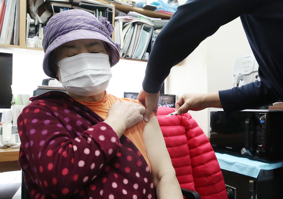 An elderly woman takes a COVID-19 vaccine booster shot at a medical clinic in Dongjak District, southern Seoul, on Monday, as such shots for people aged 75 or over began nationwide the same day. [YONHAP]