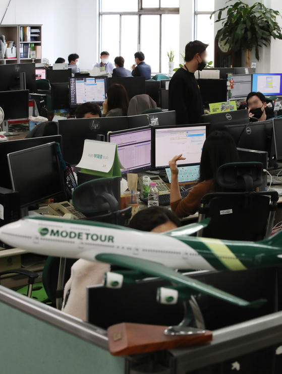 Employees are hard at work at a Mode Tour office in Jung District, central Seoul on Monday. Korea is to ease social distancing measures and begin to gradually return to normal life starting early November, and travel agencies are expecting flight and travel bookings to increase. [YONHAP]