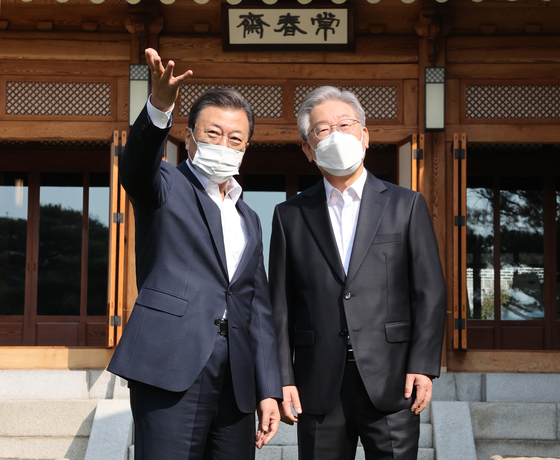 President Moon Jae-in, left, and Lee Jae-myung, the presidential candidate for the ruling Democratic Party (DP), take a commemorative photo ahead of their 50-minute tea meeting at the Blue House in central Seoul on Tuesday. [YONHAP]