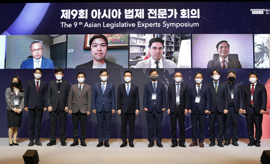 Attendees of the 9th Asian Legislative Experts Symposium at JW Marriott Seoul in Seocho District, southern Seoul, gather onstage Wednesday for a commemorative photo. From fifth from far left are Kim Kye-hong, president of the Korea Legislation Research Institute; Lee Kang-seop, minister of government legislation; Hong Jang-pyo, president of the Korea Development Institute; and Ko Hak-soo, professor at Seoul National University School of Law. [PARK SANG-MOON]