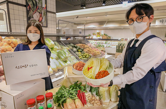 Models show a kimjang (kimchi making) kit at Hyundai Department Store that includes cabbages, radishes, red pepper powder and onions. Customers can buy the kits at 16 Hyundai Department Store branches from Nov. 9 through Dec. 15. [YONHAP] 