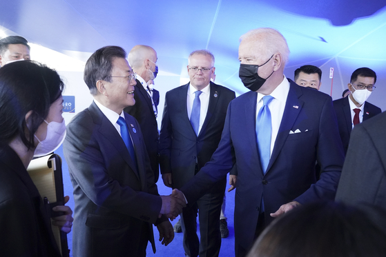 President Moon Jae-in, left, speaks briefly with U.S. President Joe Biden on the sidelines of the G-20 summit in Rome on Saturday. [YONHAP]