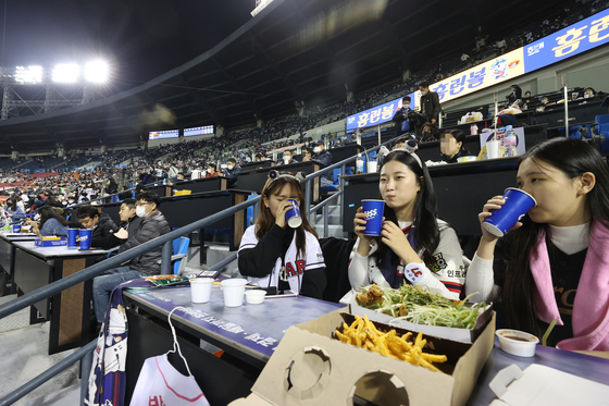 Baseball fans enjoy beer and chicken in Jamsil Baseball Stadium in Songpa District, southern Seoul, on Monday as Korea’s “With Corona” policies begin. [YONHAP]