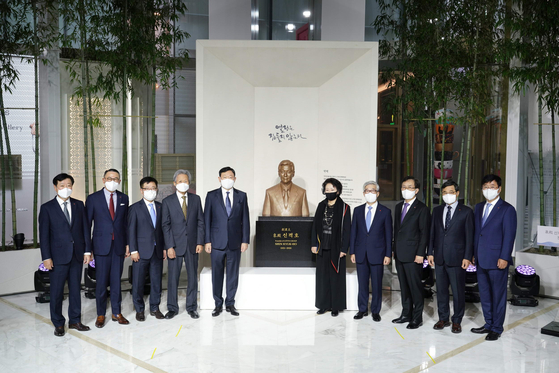 Lotte Group Chairman Shin Dong-bin, fifth from left, and Shin Young-ja, former chairman of the Lotte Scholarship Foundation, fifth from right, stand in front of the group founder Shin Kyuk-ho’s bust at Lotte World Tower in Songpa District, southern Seoul, on Monday. [LOTTE CORPORATION]