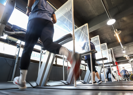 People work out at a gym in Seoul on Tuesday, the second day of the government's newly implemented "With Corona" scheme. A vaccine pass system, which requires visitors to have a vaccination certificate or negative test result, will be also introduced, with a grace period, for entry into high-risk facilities including indoor sports facilities. [YONHAP]