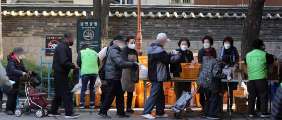 As the nation returns to normalcy, volunteers resume their work and hand out free meals to seniors in Tapgol Park in Jongro District, central Seoul, on Wednesday [NEWS1]